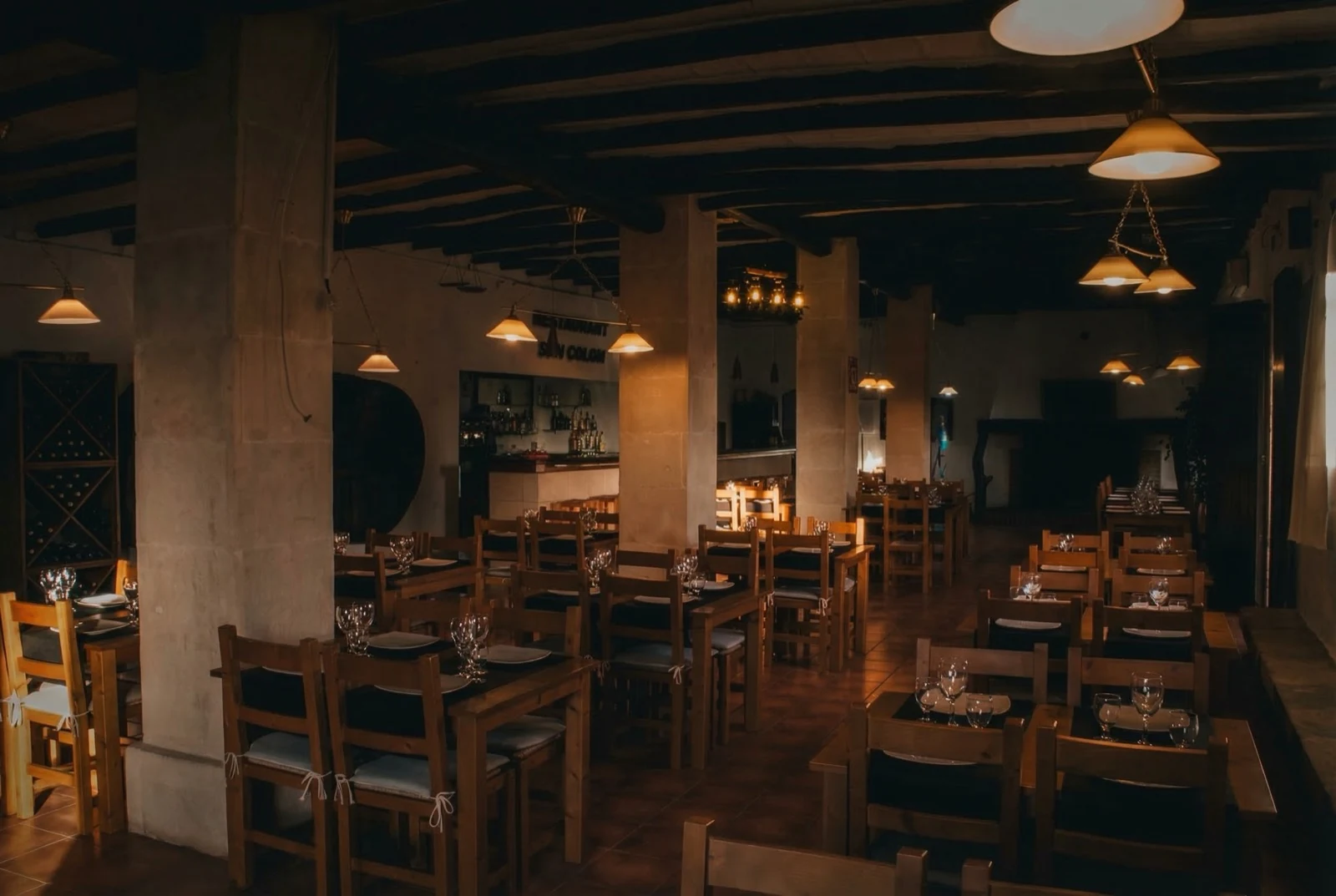 Interior del restaurante Son Colom con vinoteca y vigas de madera